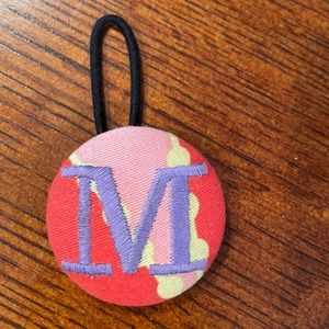 Fabric M ponytail holder. Never worn